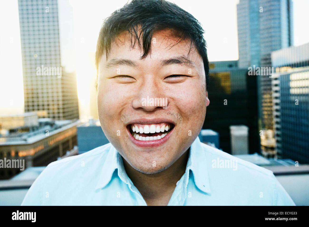 Koreanische Mann lächelnd auf städtischen Dach Stockfoto