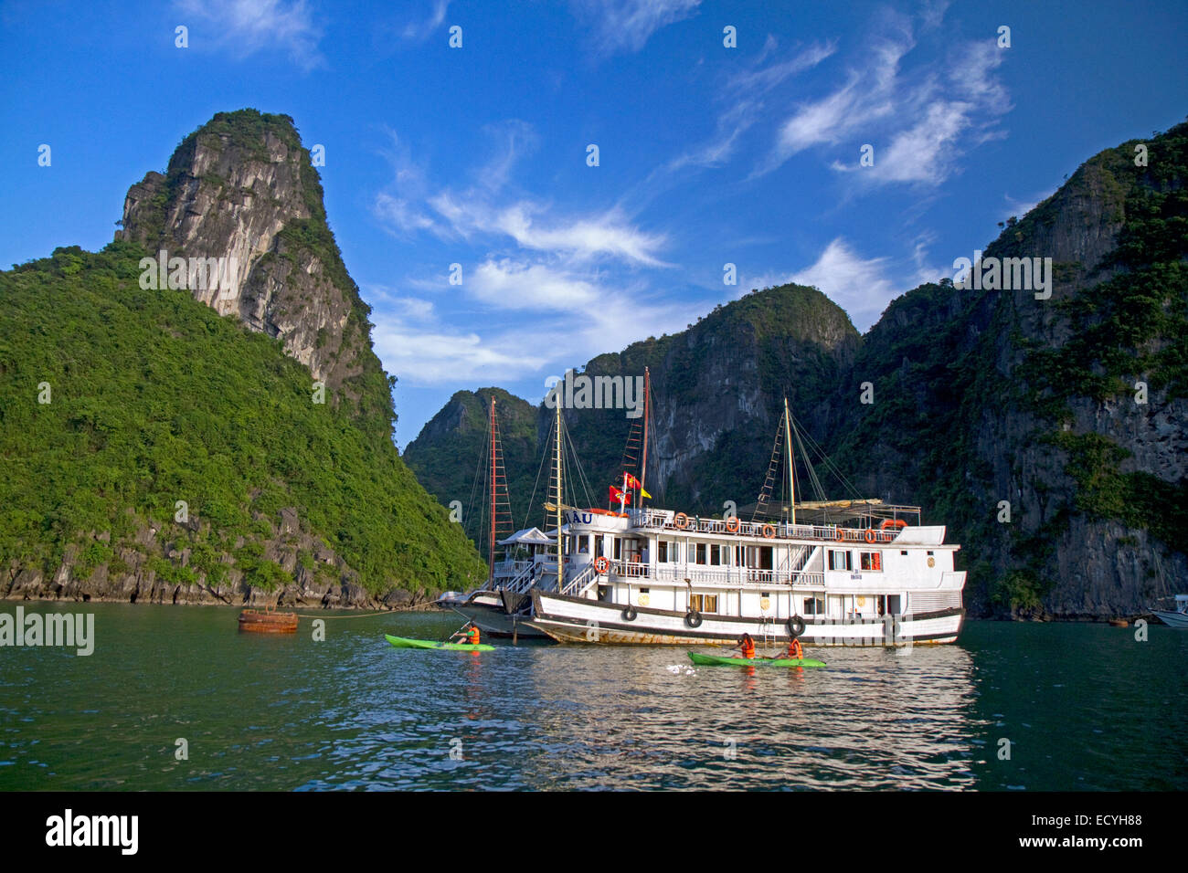 Ausflugsschiff und Touristen mit Seekajaks in Ha Long Bucht, Vietnam. Stockfoto