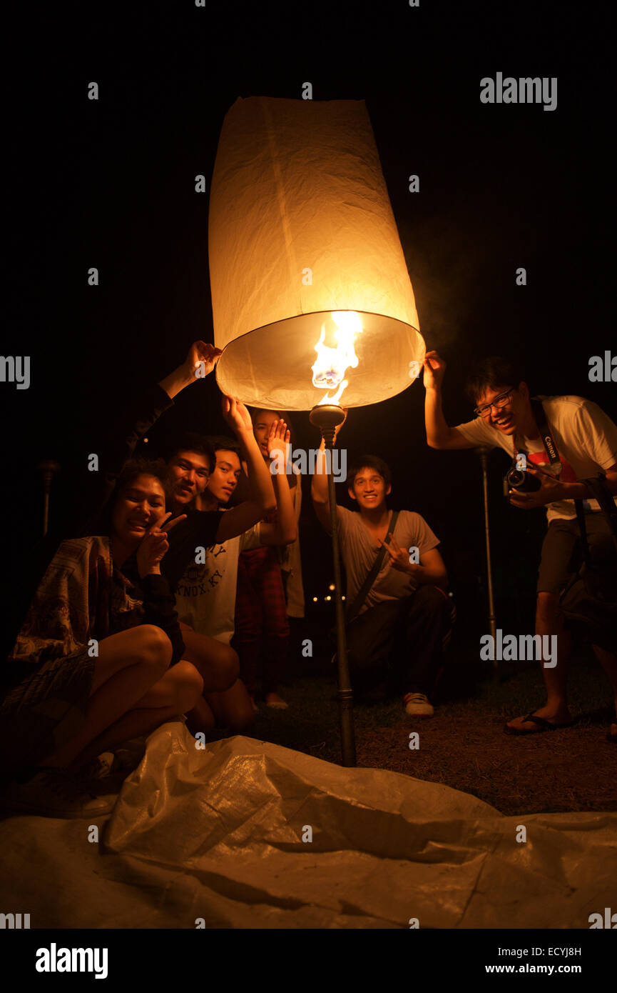 CHIANG MAI, THAILAND - 25. Oktober 2014: Gruppe von jungen Thais starten eine Himmelslaterne in der Nacht des Yi Peng Festival. Stockfoto