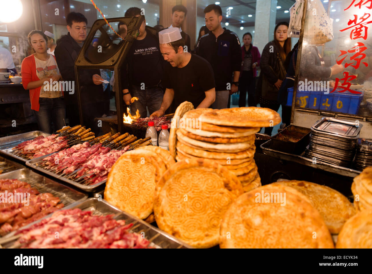 Person Kebab Herstellung und Verkauf von Nang Brot beim Bei Yuan Männer muslimischen Lebens Nachtmarkt in Xi ' an, Shaanxi, China 2014 Stockfoto