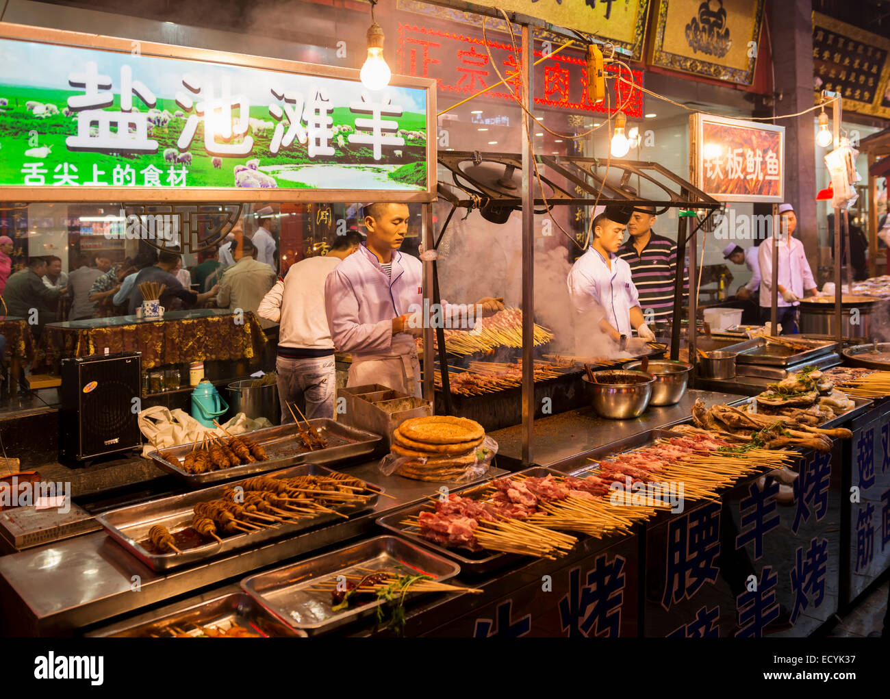 Person, die Spieße auf muslimischen Lebens Nachtmarkt in Xi ' an, Shaanxi, China 2014 Stockfoto