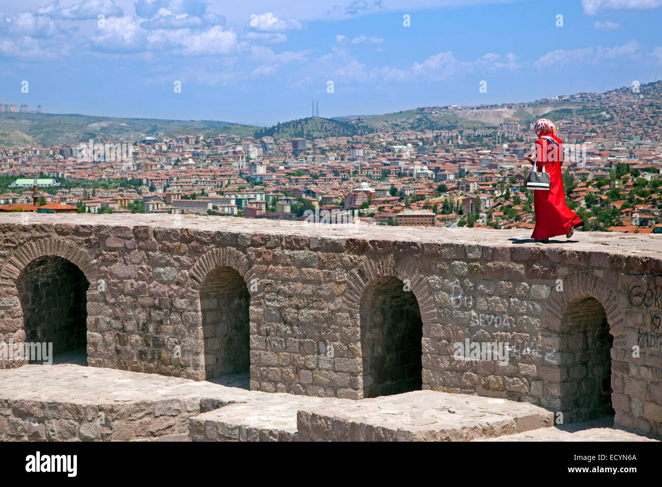 Muslimische Frau gekleidet im Stil der türkischen Hijab zu Fuß auf der alten Burgmauer mit Blick über die Stadt Ankara, Türkei Stockfoto
