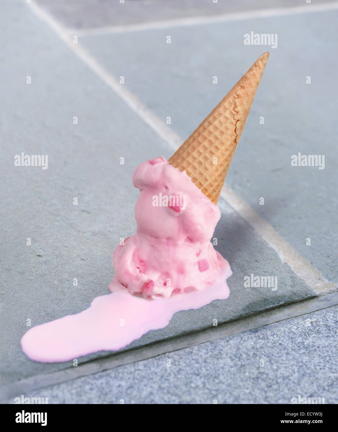 Double Dip Pink Bubble Gum Eiscreme-Kegel schmelzen oben Unten auf einem Bürgersteig Stockfoto