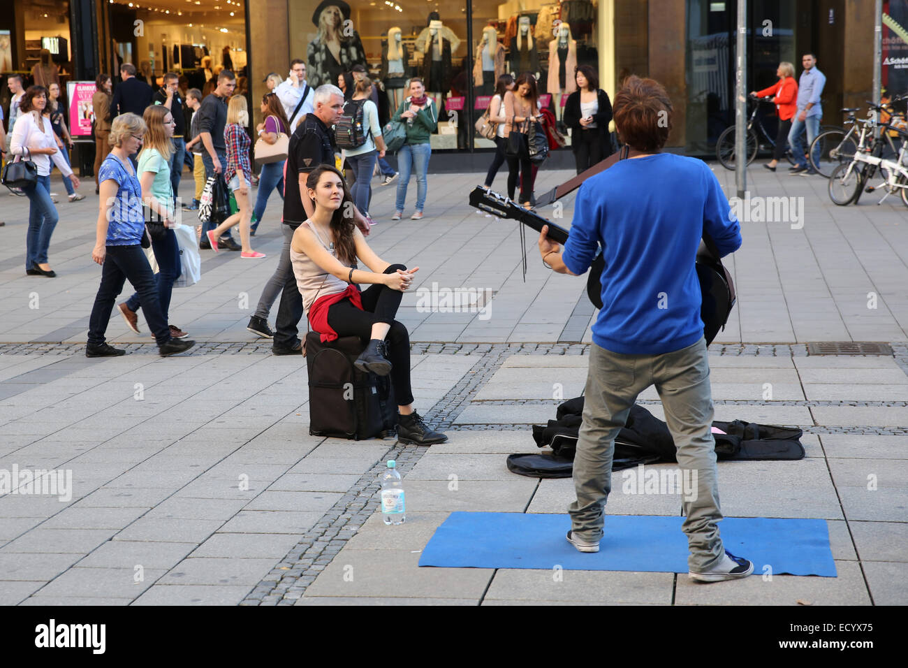 Frau beobachten männliche Straße Musiker Europas Stockfoto