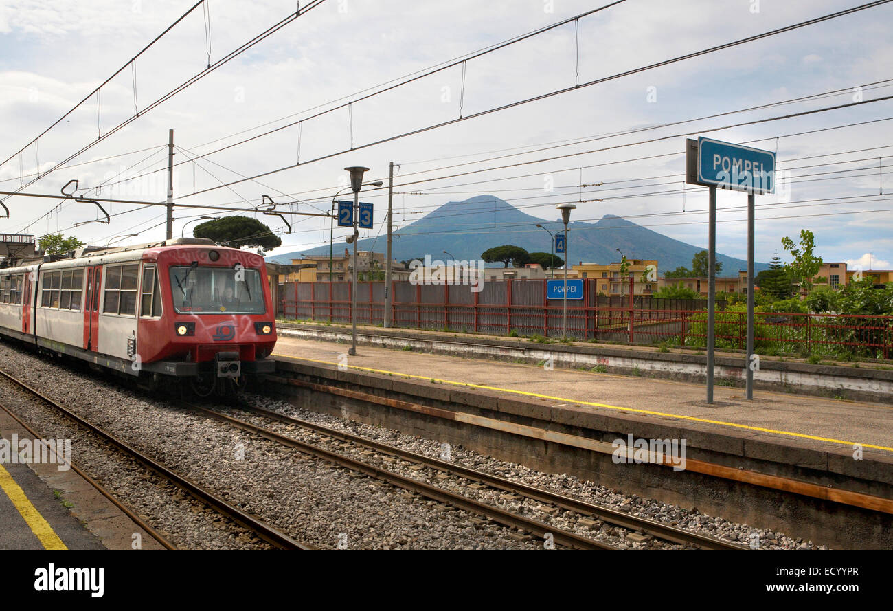 Ein Zug betritt Station in Pompeji, Italien mit Vesuv im Hintergrund. Stockfoto