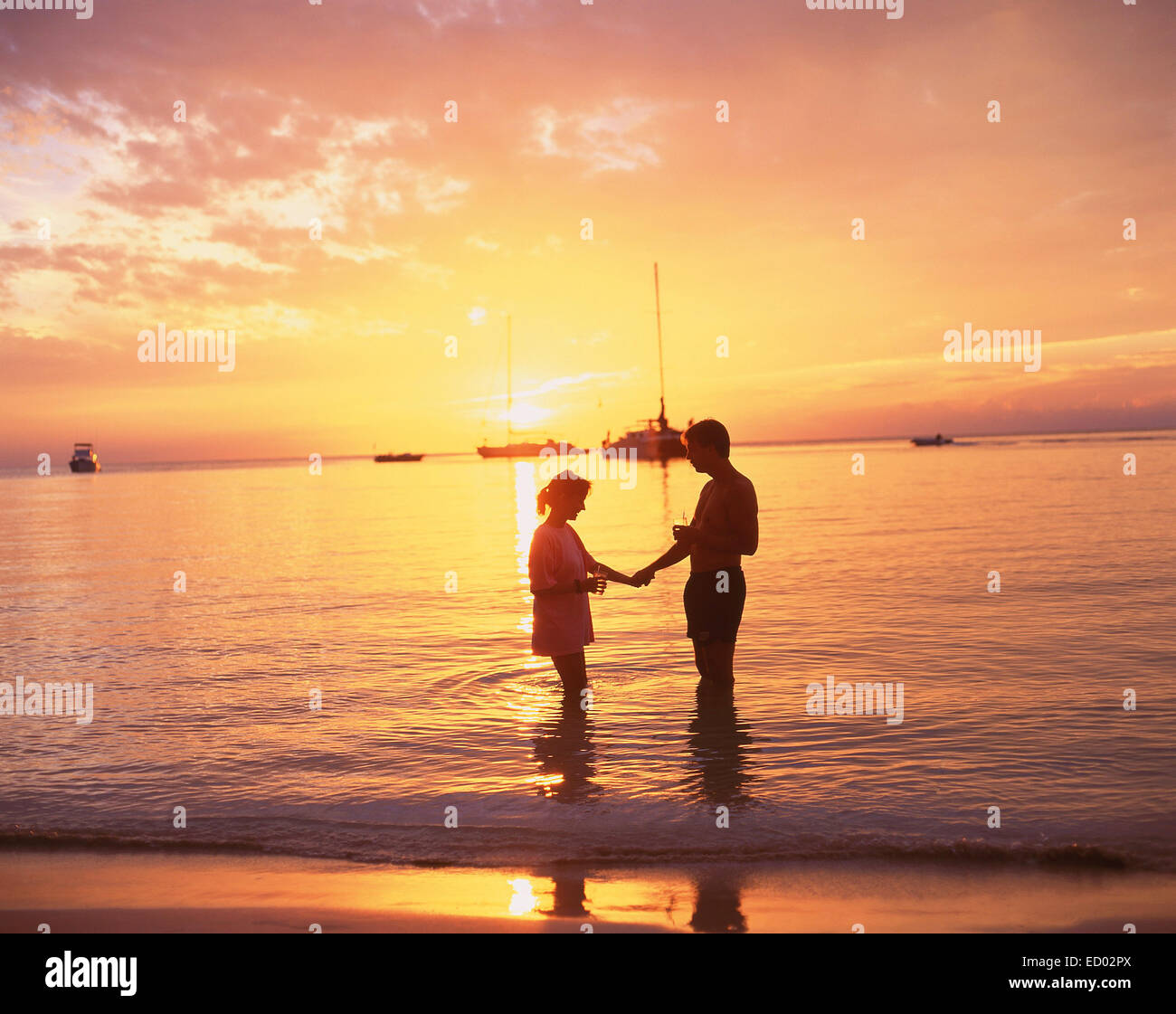 Paar im Meer bei Sonnenuntergang, Negril Beach, Negril, Westmoreland Parish, Jamaika, große Antillen, Karibik Stockfoto