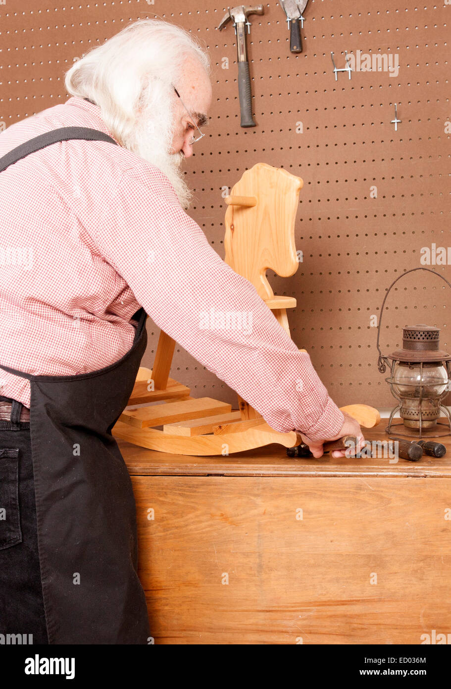 Santa arbeitet in seiner Werkstatt bauen Spielzeug Schaukelpferd. Stockfoto