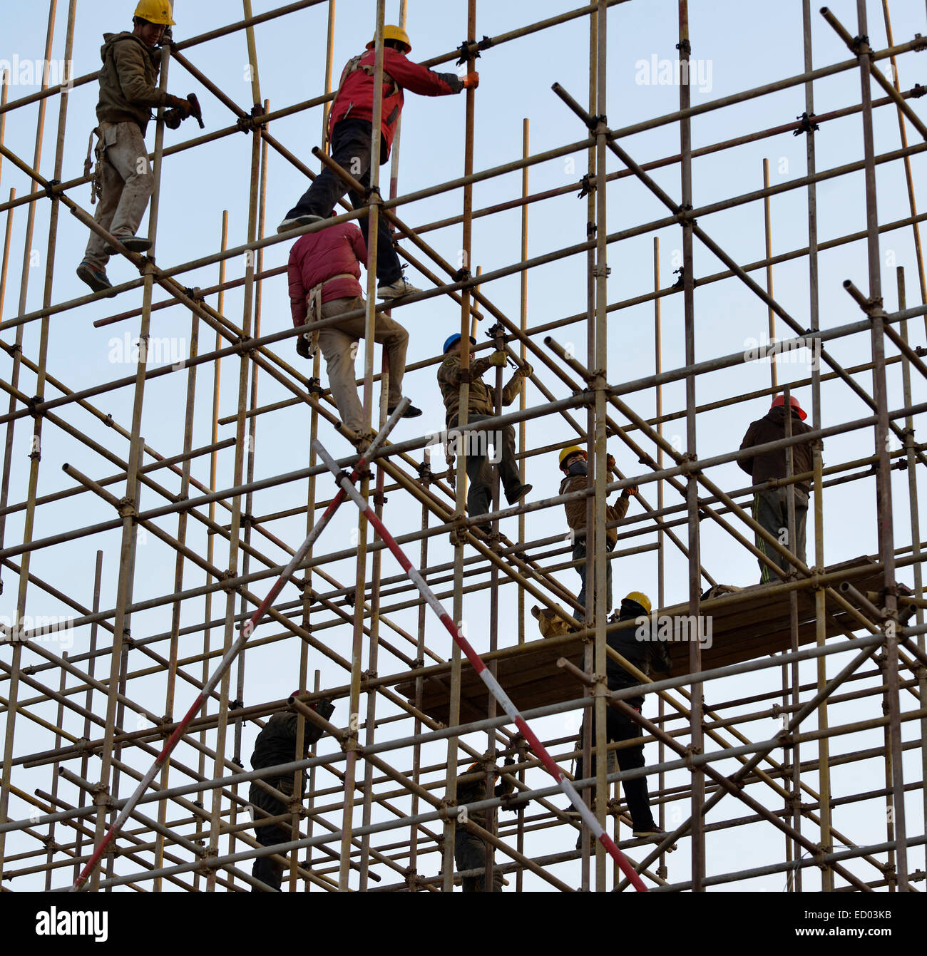 Chinesische Arbeiter arbeiten auf Gerüsten in einer Baustelle in Peking, China. Stockfoto