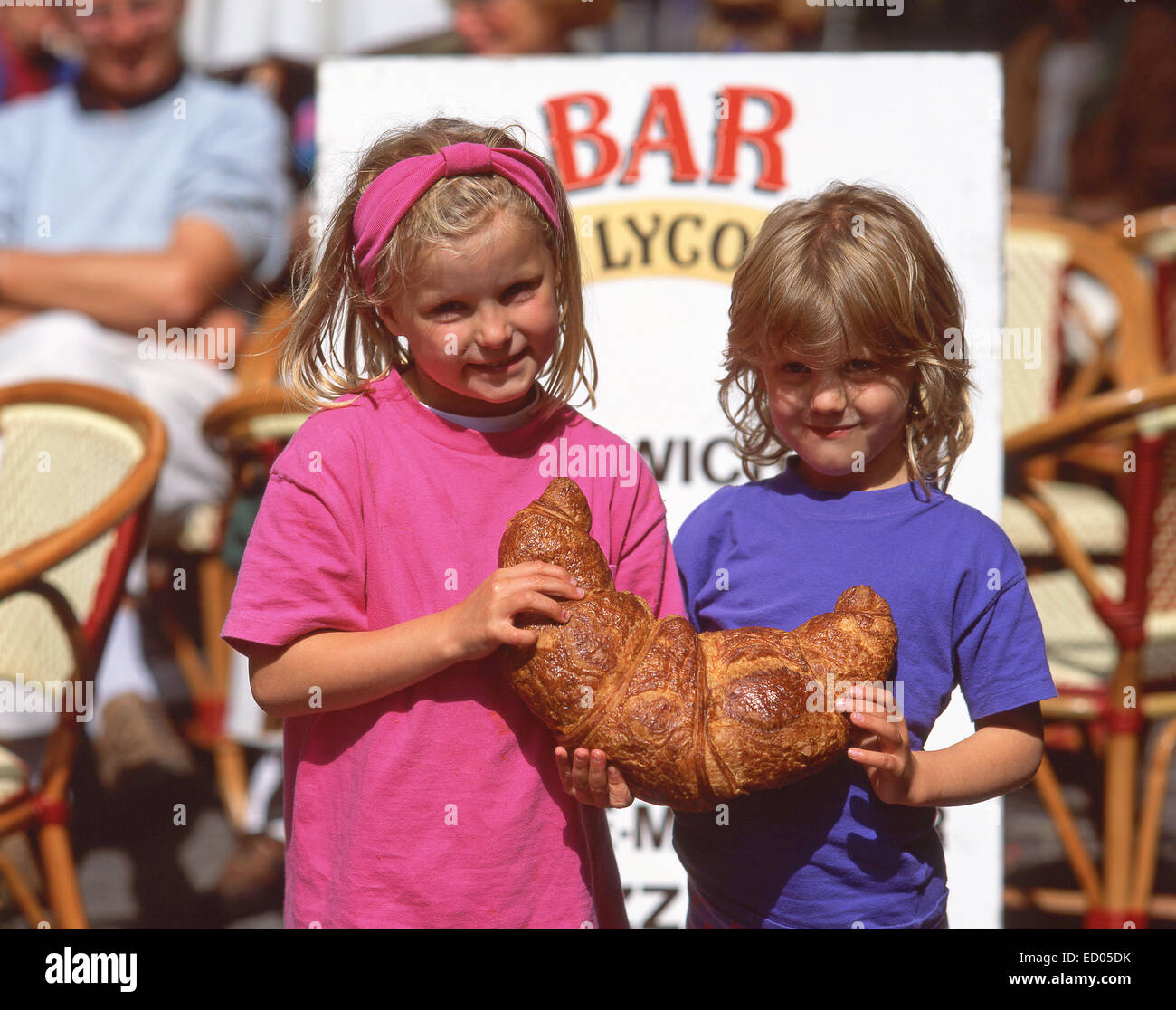 Junge Mädchen mit riesigen Croissant, Ort des Merciers, Dinan, Côtes-d ' Armor, Bretagne, Frankreich Stockfoto