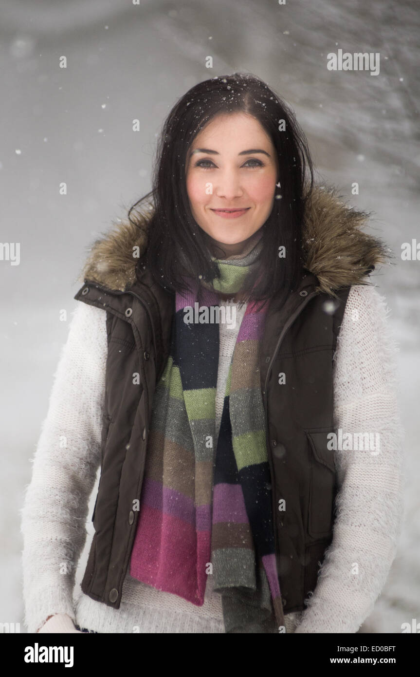 Im Schnee lächelnde Frau Stockfoto