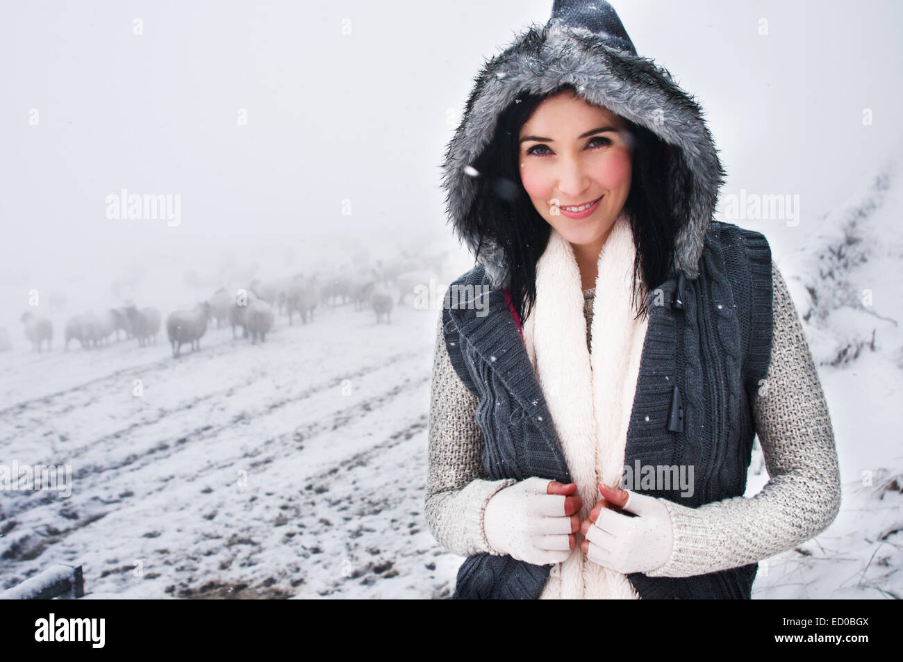 Porträt der lächelnde Frau in schneebedeckten Feld Stockfoto