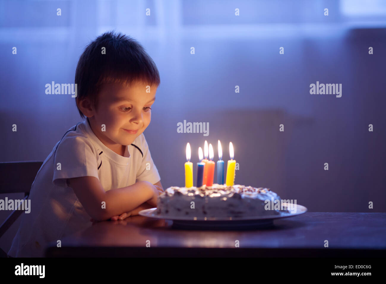 Junge über die Luft blasen Kerzen auf seinem Geburtstagskuchen Stockfoto