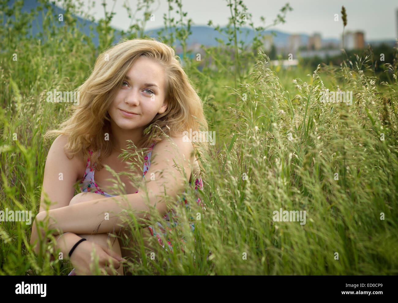 Porträt von Teenager-Mädchen (14-15) sitzen im Feld Stockfoto