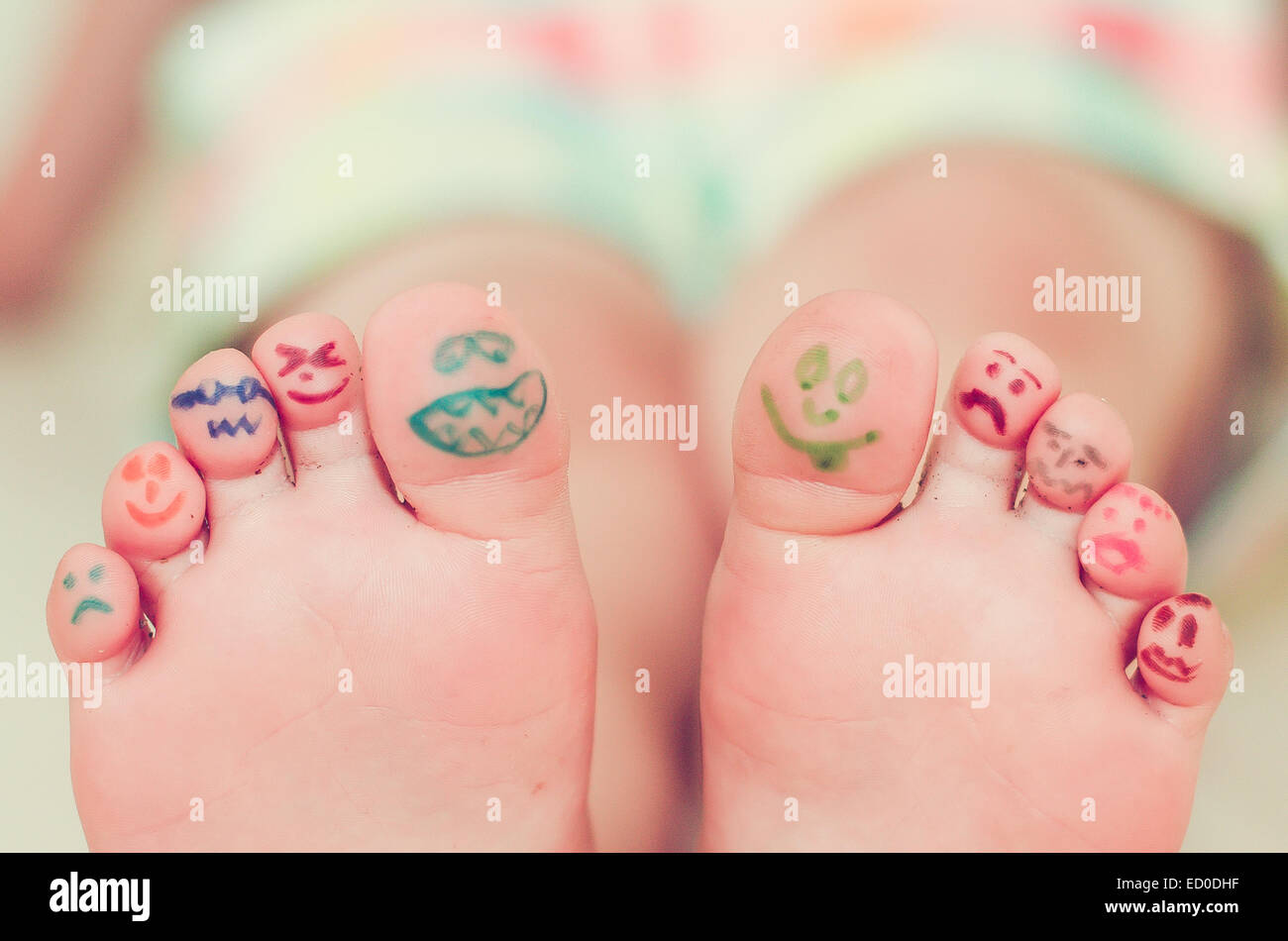 Mädchen Füße mit Smiley-Gesicht-Zeichnungen Stockfoto