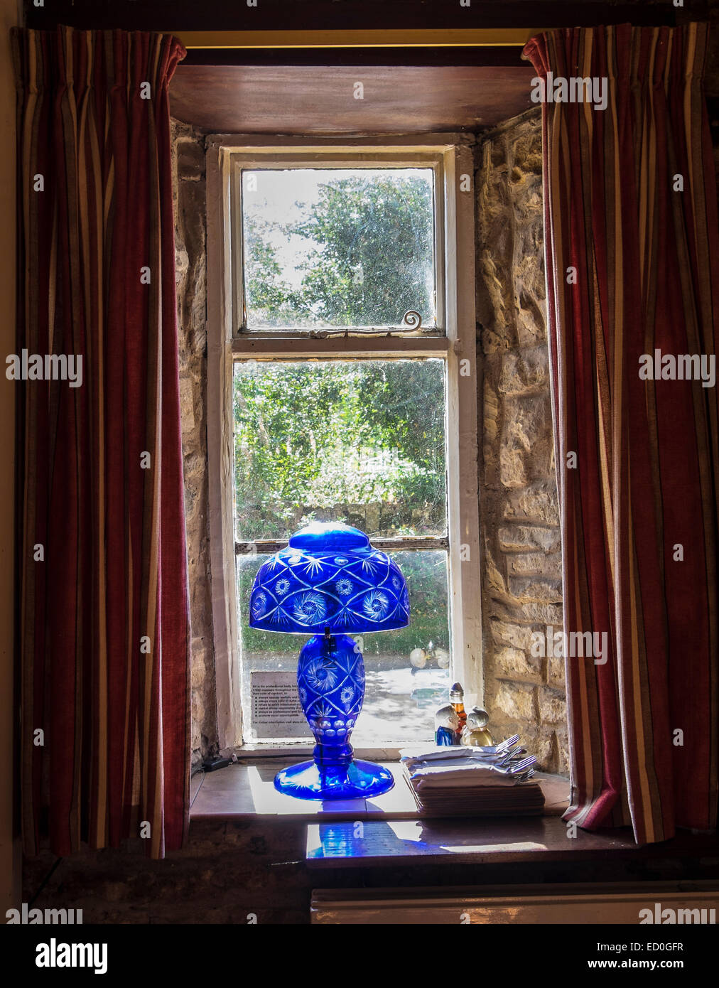 Blaues Glaslampe im Fenster der Landwirte Arme Guiting Power The Cotswolds Gloucestershire, England Stockfoto