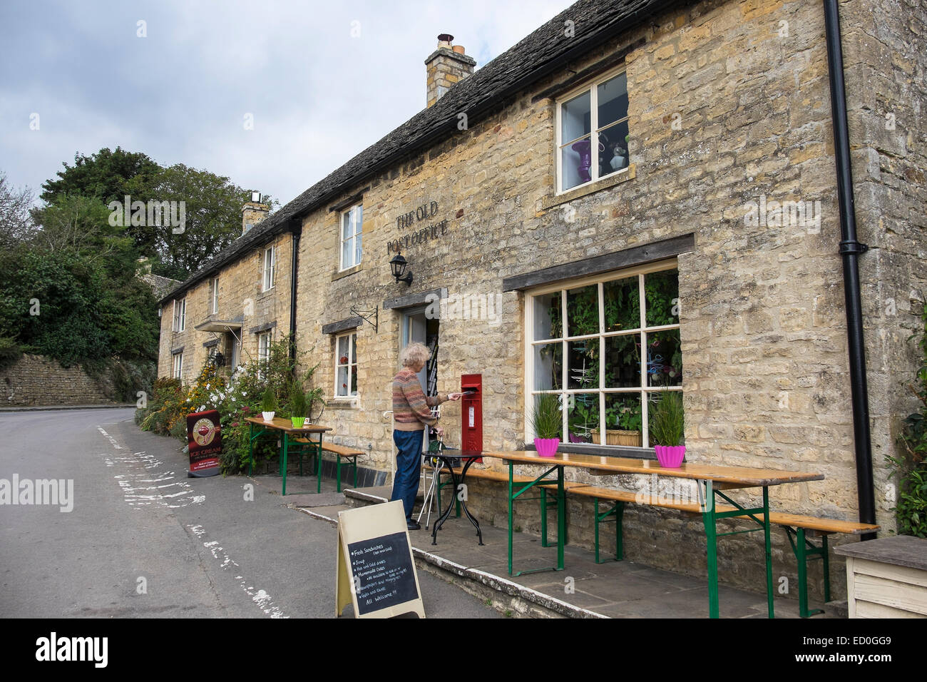 Lady, die Entsendung der altes Post und Cotswold Steinhütten The Square Guiting Power The Cotswolds Gloucestershire, England Stockfoto