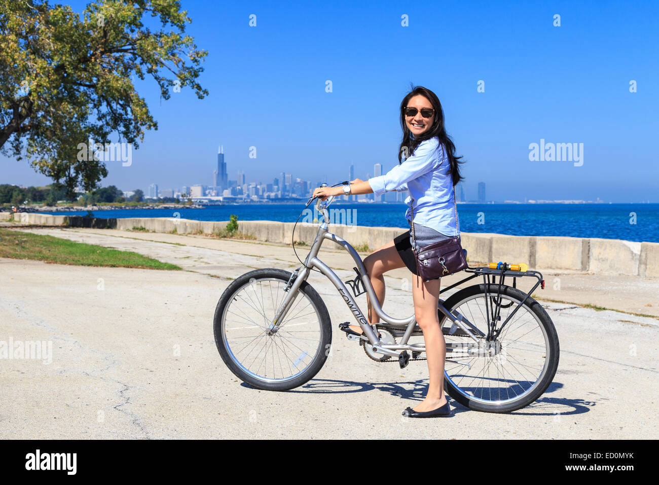 Junge asiatische Frau, die ihr Fahrrad am Lake Michigan in der South Side von Chicago, IL, USA. Stockfoto