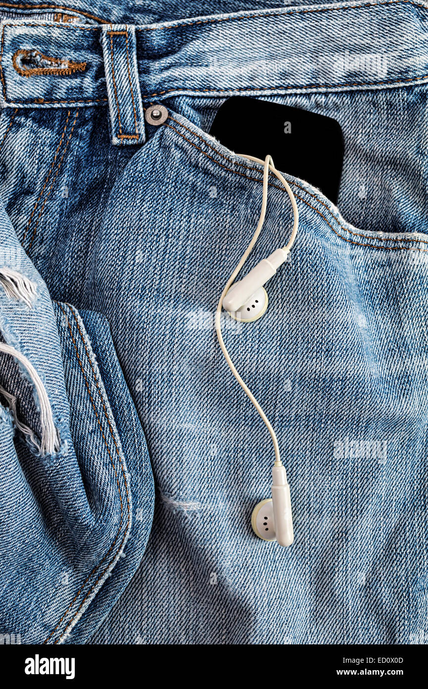 MP3-Player und Kopfhörer ragte aus Jeans-Tasche Stockfoto