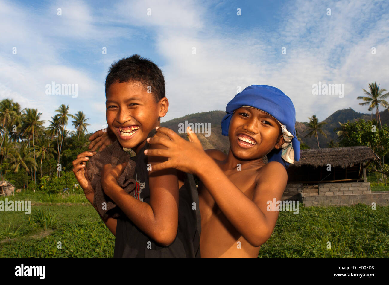 Zwei junge Leute, die Spaß in einem Feld in der Nähe von Dorf Amed Ost Bali Fischereikultur. Amed ist ein langer Küstenstreifen von fishi Stockfoto