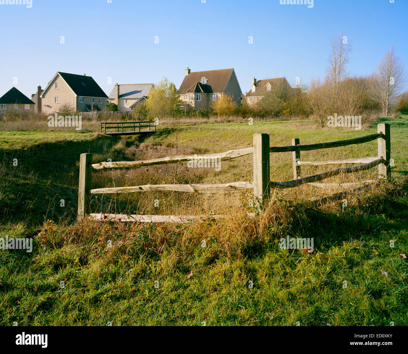 Zaun, Steg und Häuser in Eichen-Holz-Wildreservat in Cambourne Cambridgeshire Stockfoto