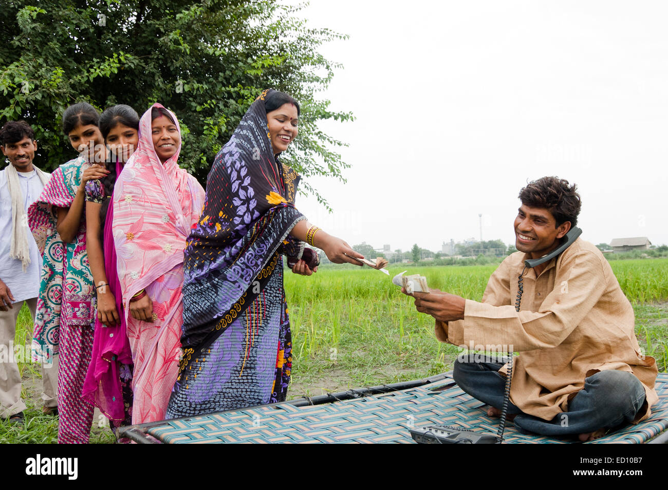 1 indischen ländlichen Bauern sprechen Telefon und Arbeit Geld geben Stockfoto