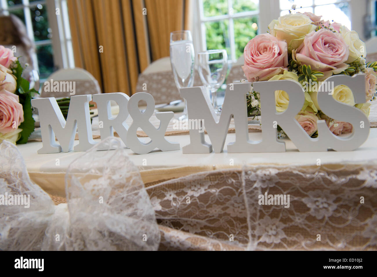 Hochzeit Tag Details: Herr und Frau Platzhalter am Tisch für Braut und Bräutigam bei der Hochzeit Frühstück Empfang Party mit die Braut Blumen auf dem Tisch hinter Stockfoto