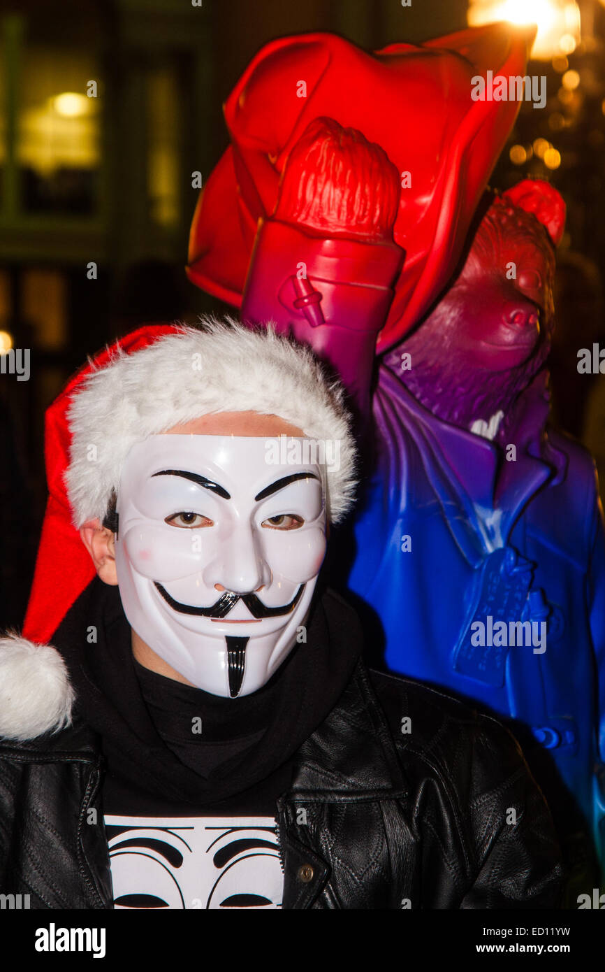 London, UK. 23. Dezember 2014. Online-Aktivismus-Gruppe Anonymous marschieren durch London von der Stadt zum Hauptquartier des BBCS auf Great Portland Street aus Protest gegen angebliche Vorurteile und Jacken ein Pädophilen-Ring. Bild: Paddington Bear posiert mit ein Demonstrant in seiner Guido Fawkes Maske. Bildnachweis: Paul Davey/Alamy Live-Nachrichten Stockfoto