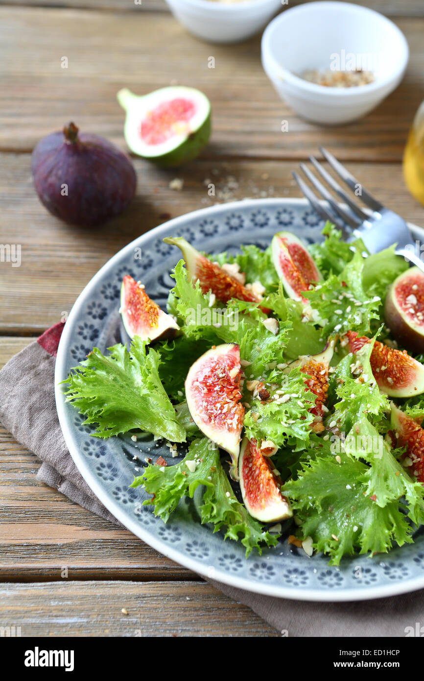 Köstlicher Salat mit Feigen und Salat auf einem hölzernen Hintergrund Stockfoto