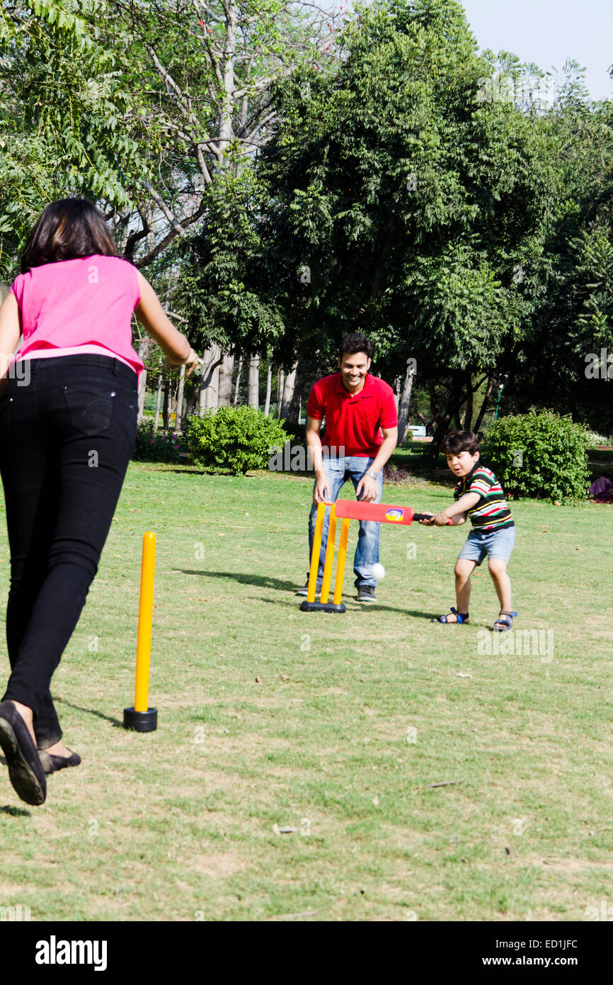 indische Eltern mit Kind Parken spielen Cricket Stockfoto