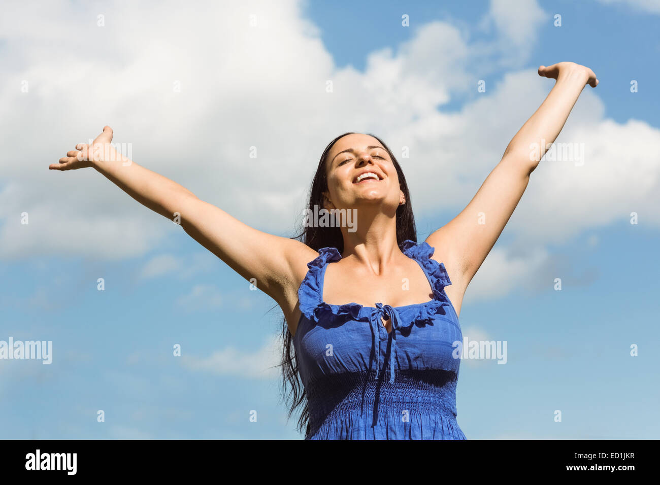 Lächelnde Brünette im blauen Kleid frei fühlen Stockfoto