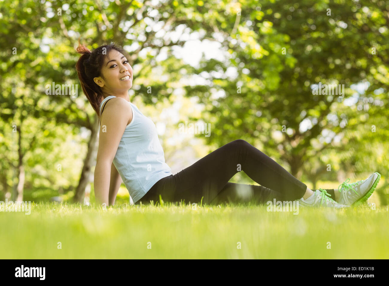 Gesunde Frau sitzen auf dem Rasen im park Stockfoto