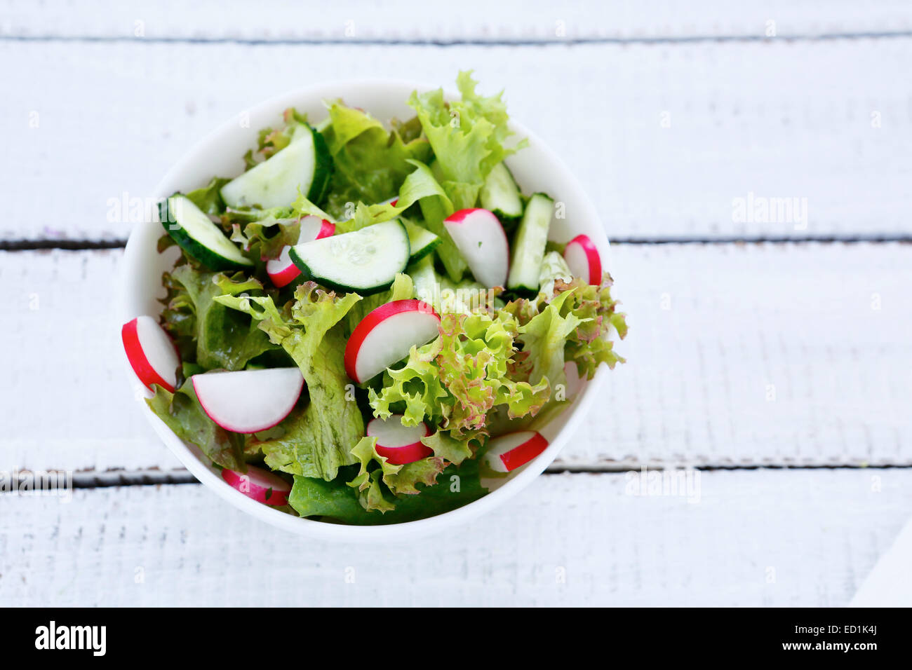 Salat mit Kopfsalat, Gurken und Radieschen in eine Schüssel geben, vegetarische Kost, Ansicht von oben Stockfoto