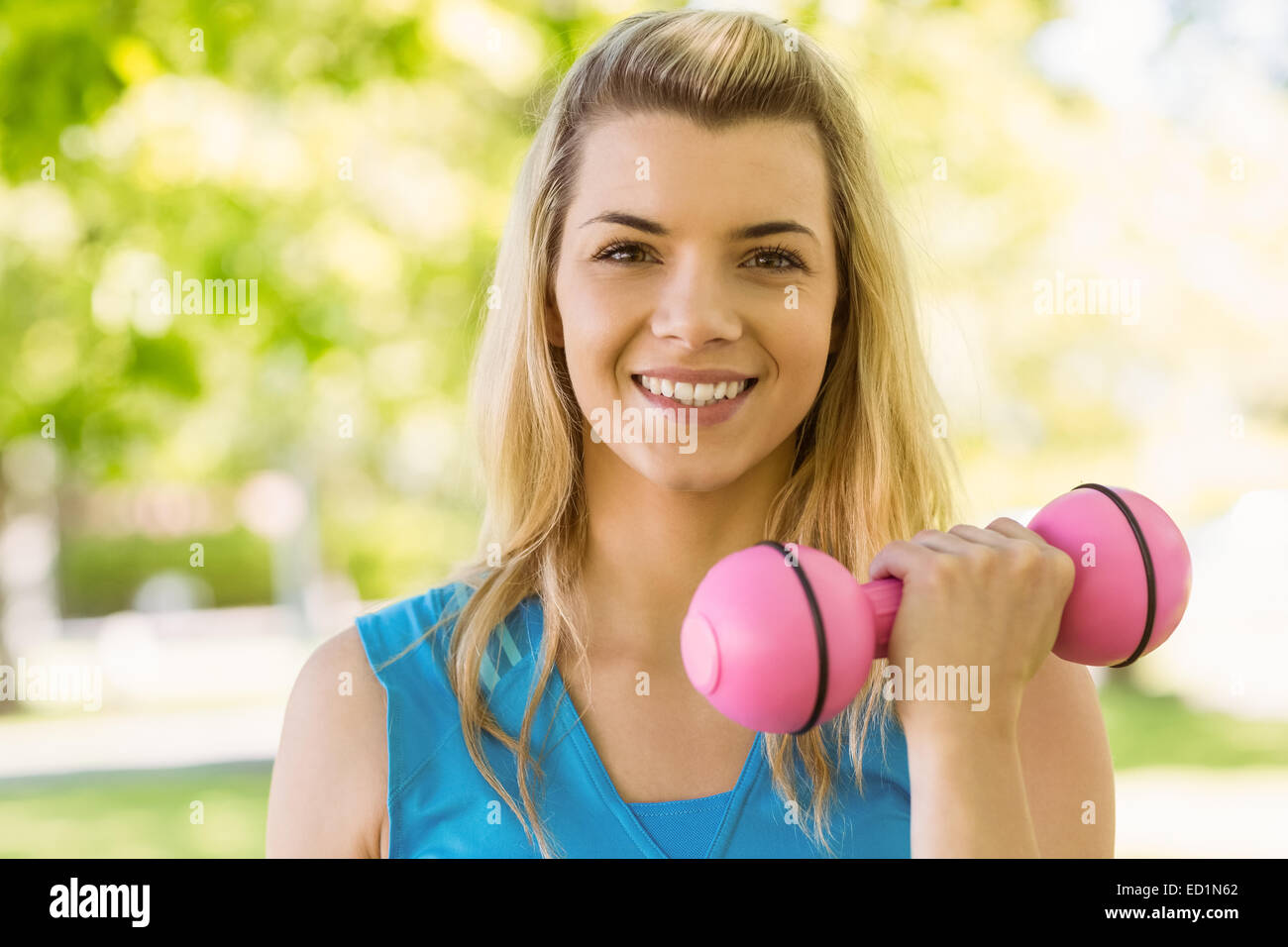 Fit Blonde Aufhebung Hanteln im park Stockfoto