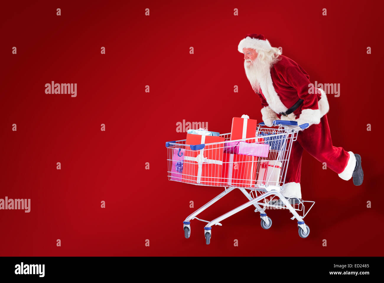Zusammengesetztes Bild von Santa schiebt einen Einkaufswagen Stockfoto