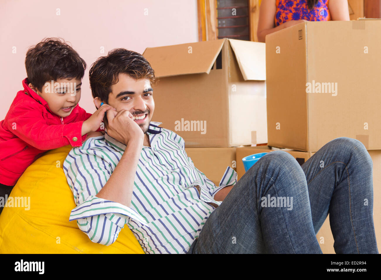 indische Eltern und Sohn nach Hause sprechendes Telefon Stockfoto