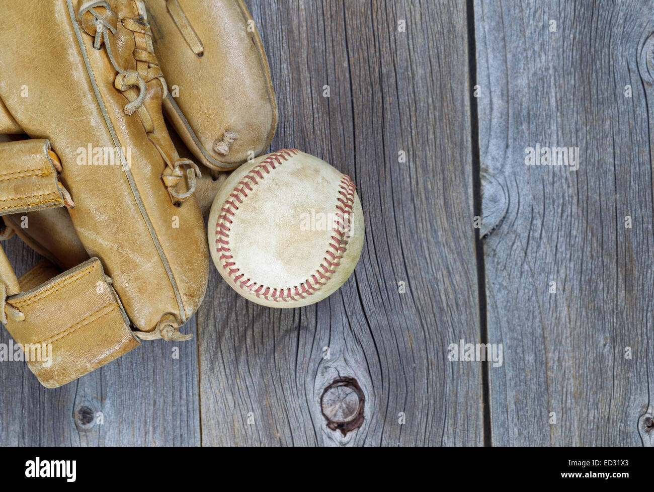 Teilweise alte abgenutzte Handschuh und gebrauchte Baseball auf rustikalen Holz Stockfoto