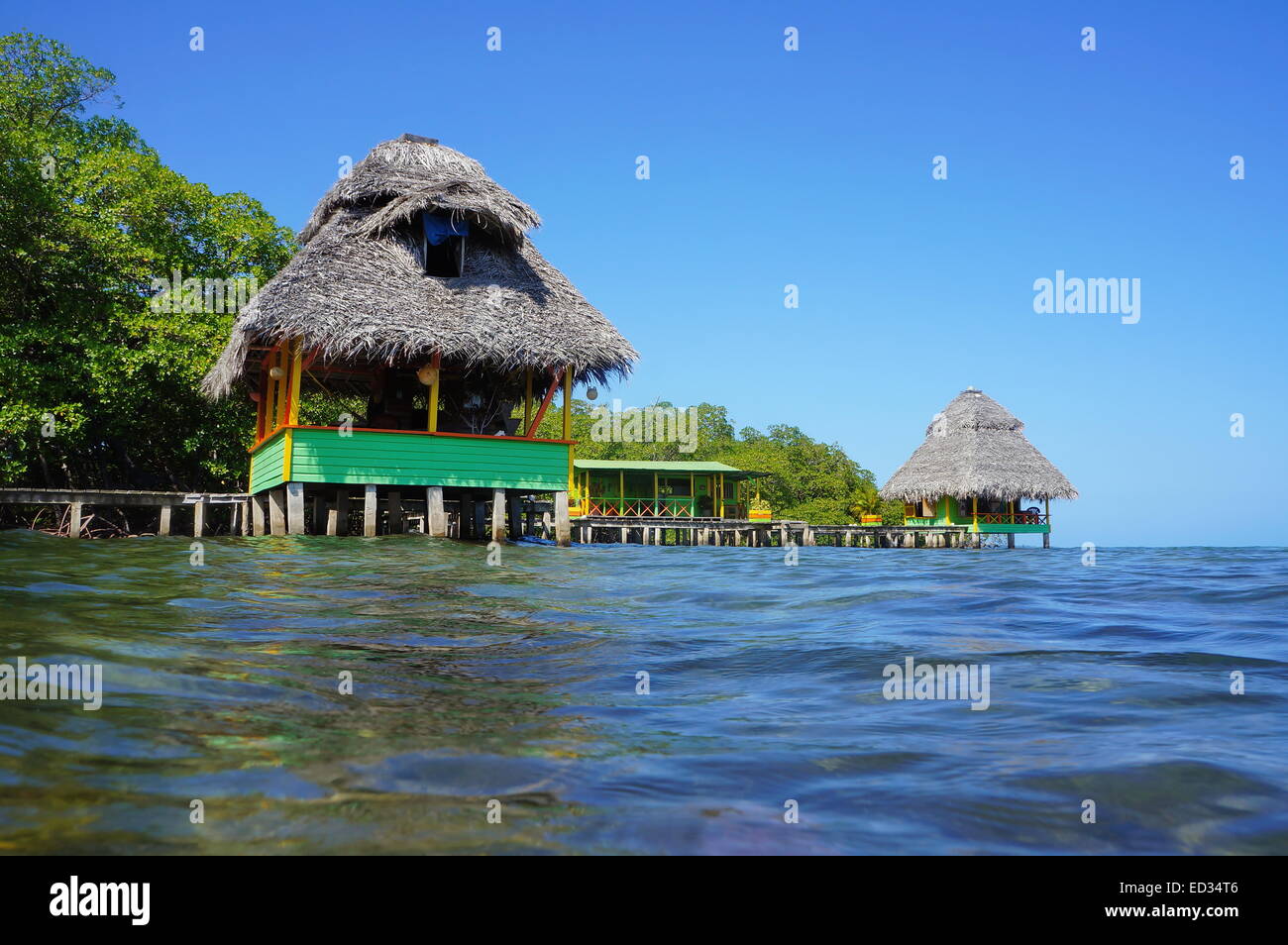 Tropischen Hütten mit Strohdach über dem Meer, Karibik, Bocas del Toro, Panama Stockfoto