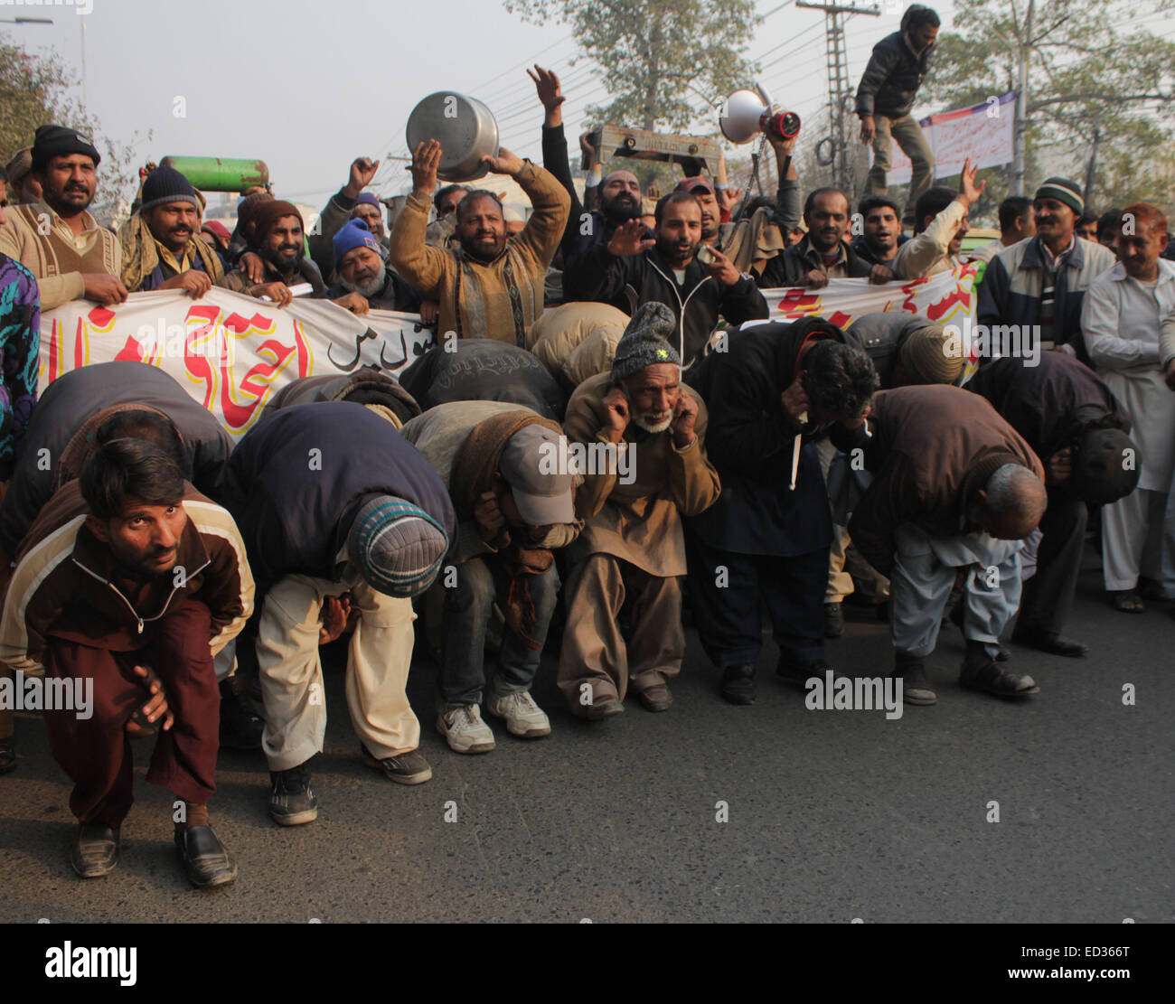 Lahore, Pakistan. 24. Dezember 2014. Pakistanische Rikschafahrer und Mitglieder von Awami Rikscha Union chant Parolen gegen Preis für Liquefied Petroleum Gas (LPG) und Mangel von komprimiertem Erdgas (CNG) während einer Protestaktion in Lahore wandern. Bildnachweis: Rana Sajid Hussain/Pacific Press/Alamy Live-Nachrichten Stockfoto