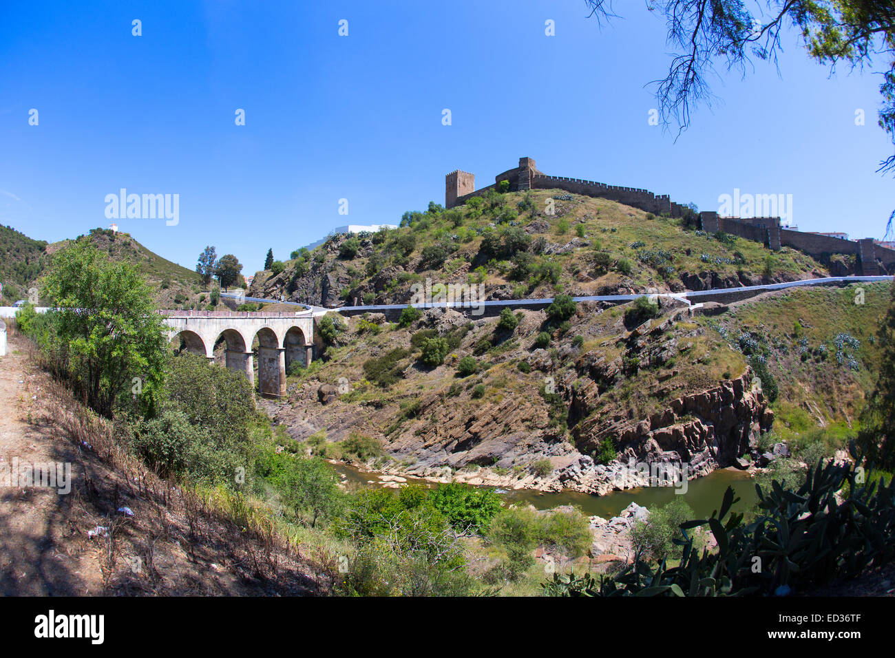Die alten Burgmauern der Stadt Mertola, im Süden Portugals. Die Brücke überquert den Fluss Guadiana. Stockfoto