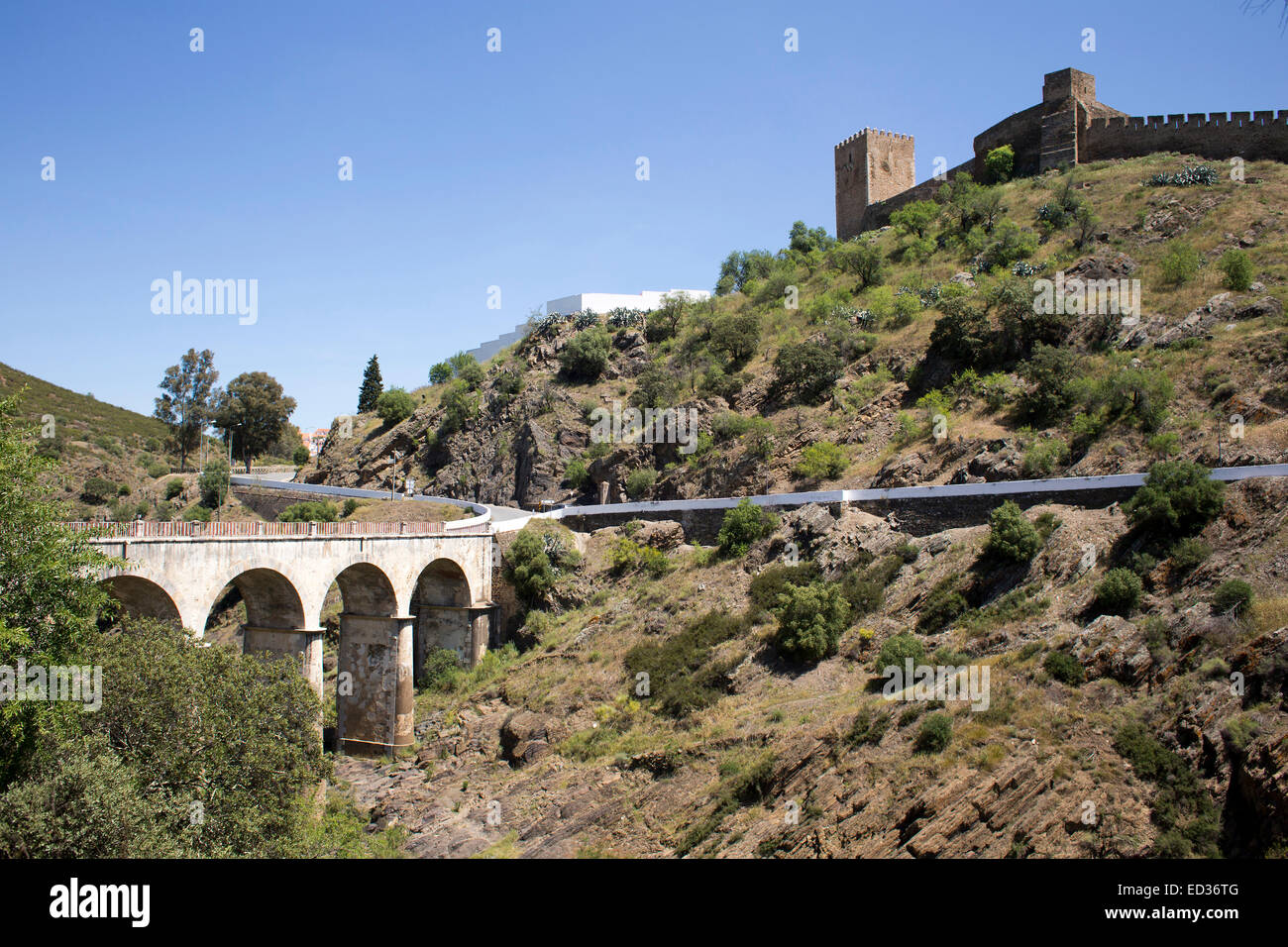 Die alten Burgmauern der Stadt Mertola, im Süden Portugals. Die Brücke überquert den Fluss Guadiana. Stockfoto