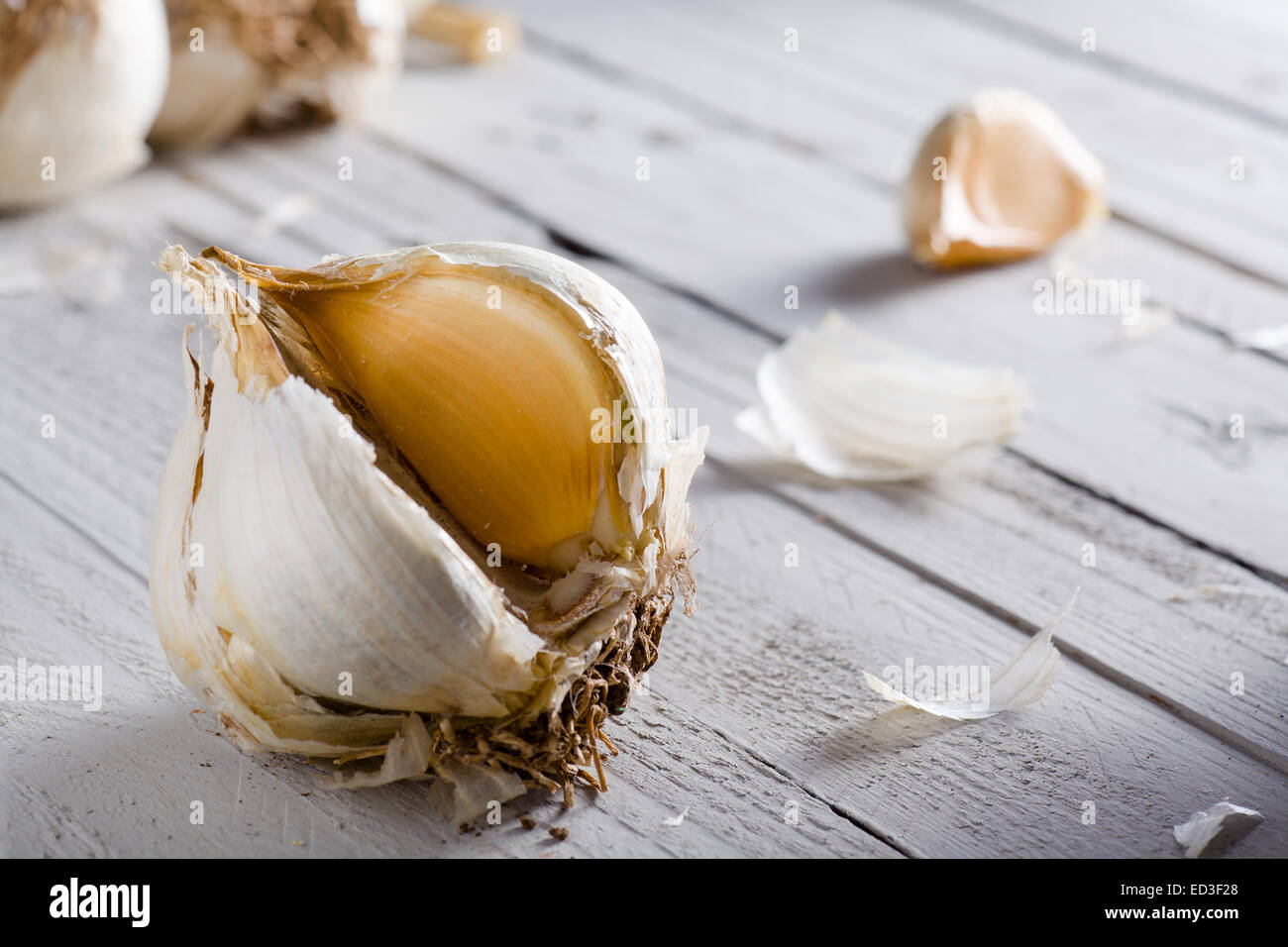 Rohe Knoblauchzehe auf weißem Holz Stockfoto