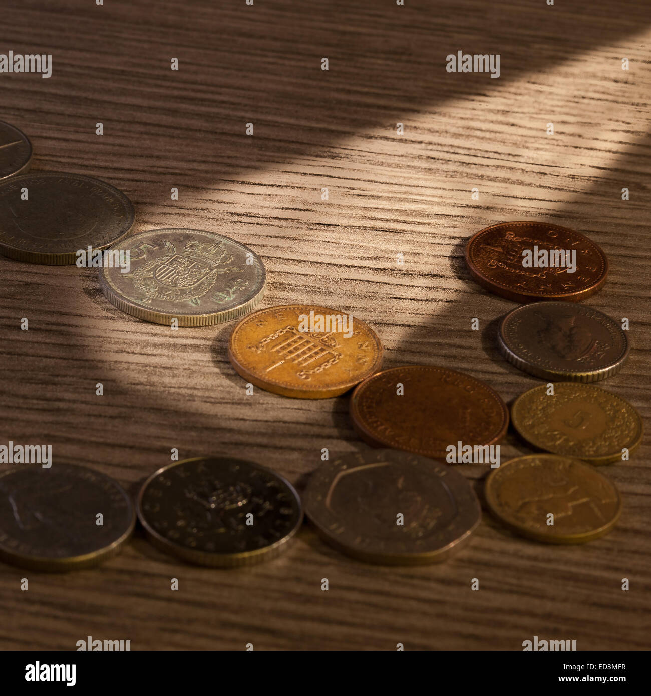 Alte Münzen Lichtstrahl. Penny und Peseta Stockfoto