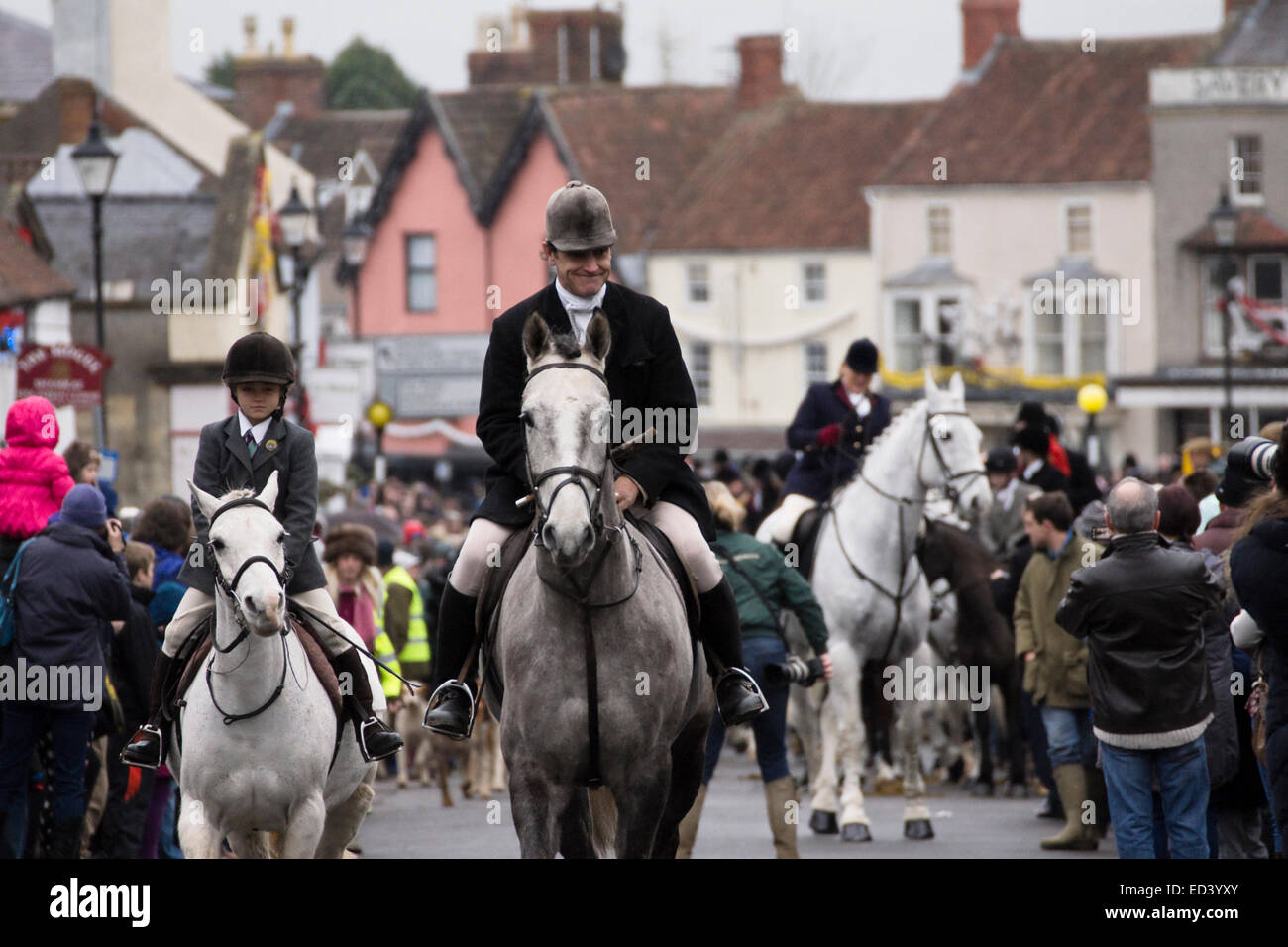 Thornbury, Gloucestershire, UK. 26. Dezember 2014. Mitglieder der Berkeley Jagd galoppieren durch Thornbury High Street zu Beginn der Boxing Day Jagd. Fuchs Jagd ist nach wie vor verboten, so die Jagd einen vorbereiteten Duft folgt. Die konservative Partei heißt es wird eine freie Abstimmung über das Huntingh-Verbot halten, wenn es Winns der 2015 Wahl. Bildnachweis: Herr Standfast/Alamy Live-Nachrichten Stockfoto