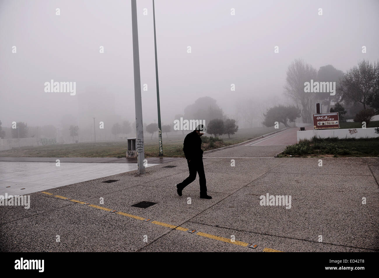 Ein Mann geht in Thessaloniki direkt am Meer unter dichtem Nebel, Griechenland Stockfoto