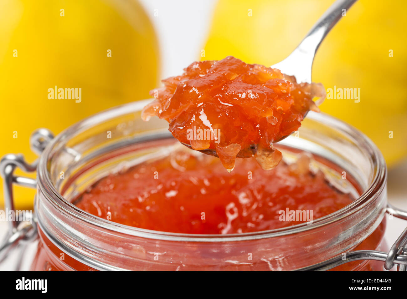 Leckeren Quitten Marmelade in einem Löffel auf Reife Quitten Hintergrund. Stockfoto