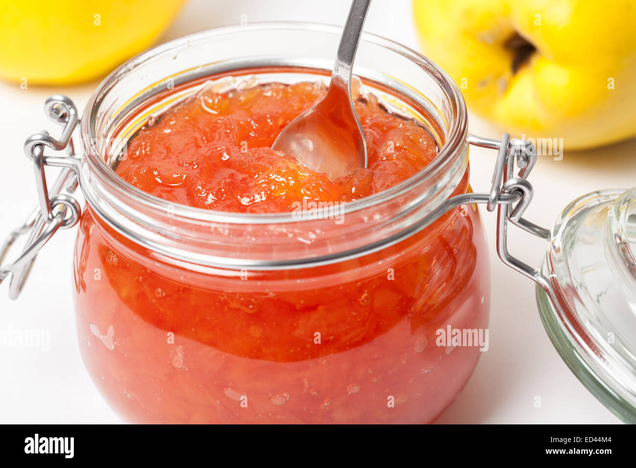 Reife Quitten und Quitten Marmelade in ein Glas isoliert auf weißem Hintergrund. Stockfoto