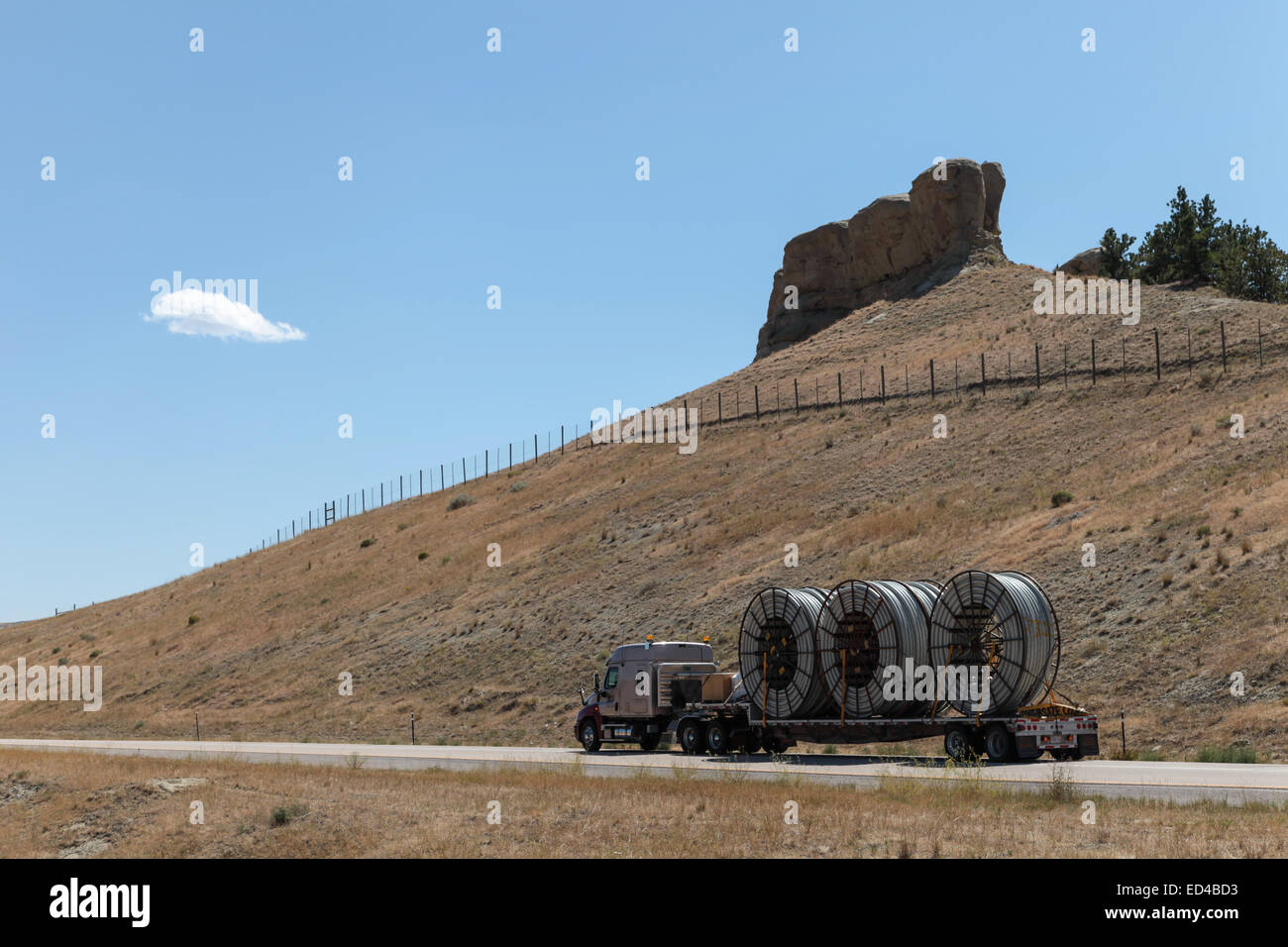 Eine amerikanische Semi Truck schleppen Rollen von HDPE-Kunststoff Rohr auf einem Tieflader für die Ölindustrie und fracking Standorten in den USA Stockfoto
