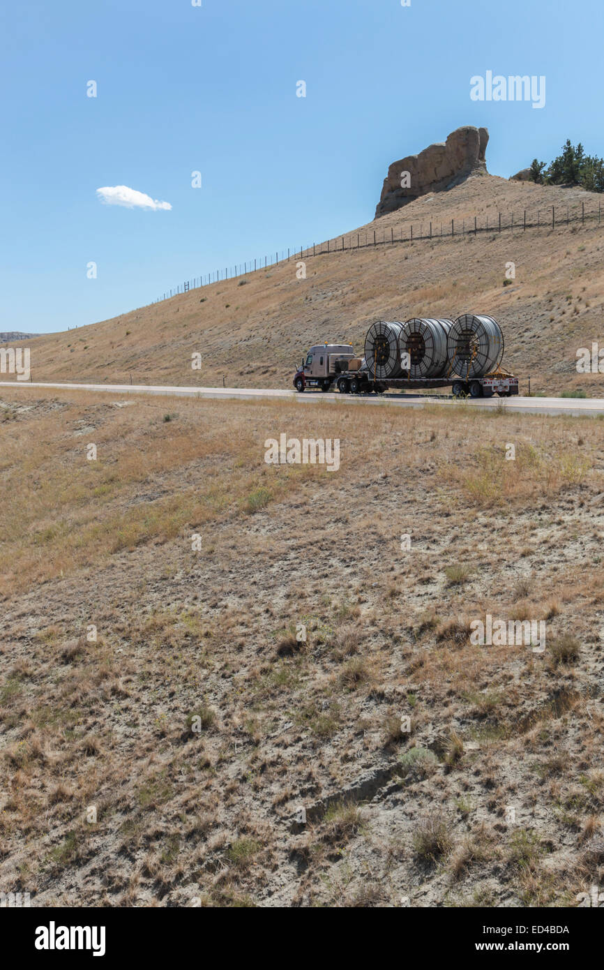 Eine amerikanische Semi Truck schleppen Rollen von HDPE-Kunststoff Rohr auf einem Tieflader für die Ölindustrie und fracking Standorten in den USA Stockfoto