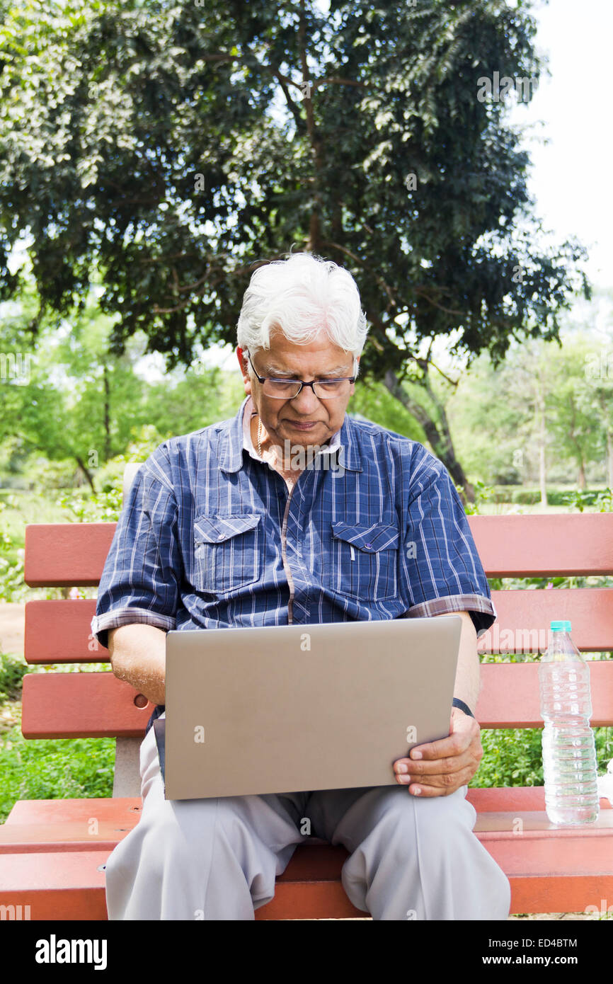 indische Greis Park Laptop arbeiten Stockfoto