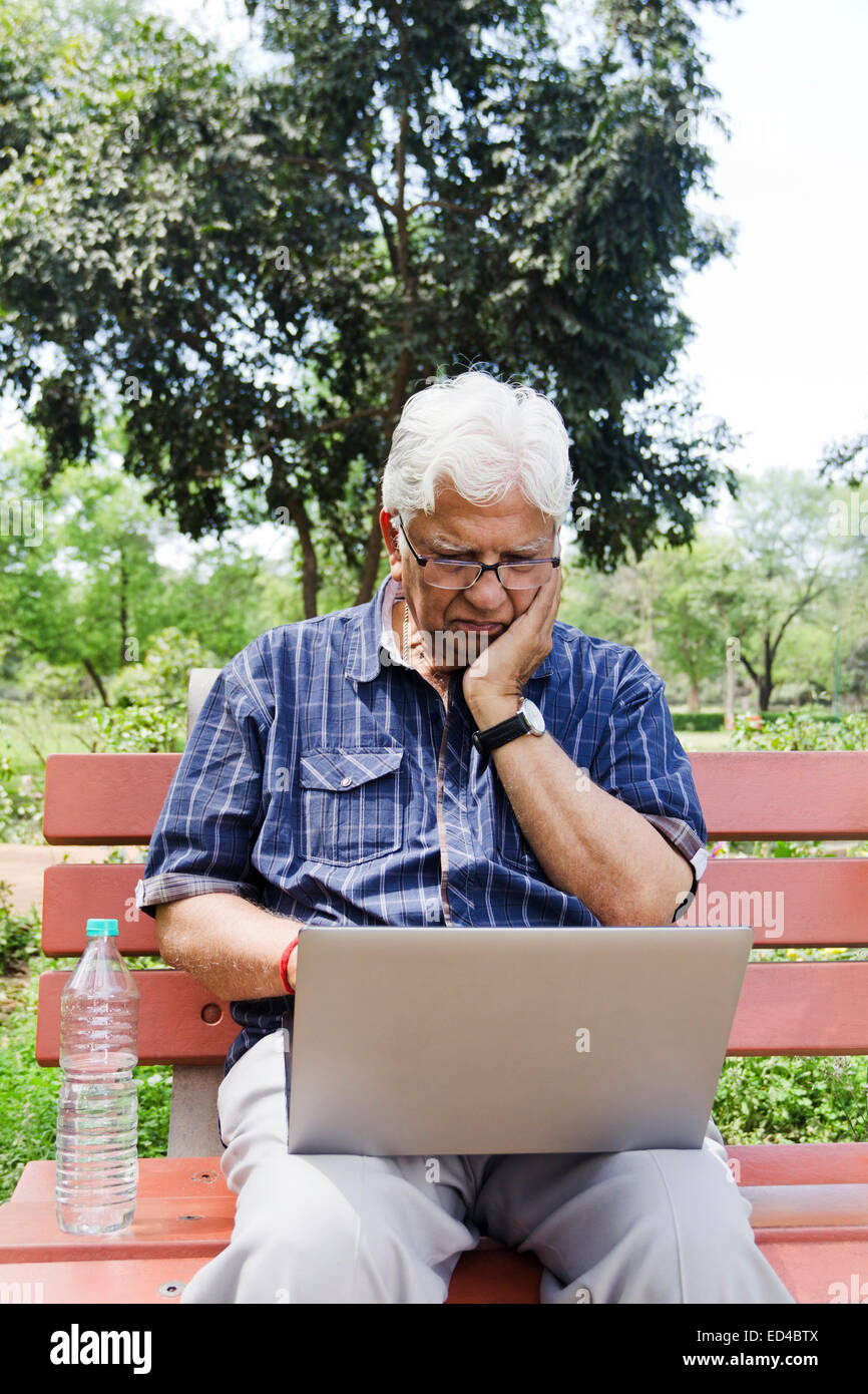 indische Greis Park Laptop arbeiten Stockfoto